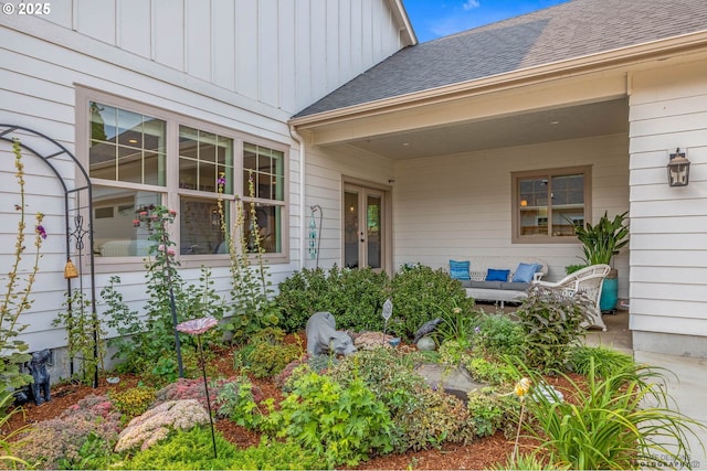 doorway to property with board and batten siding, a shingled roof, and outdoor lounge area