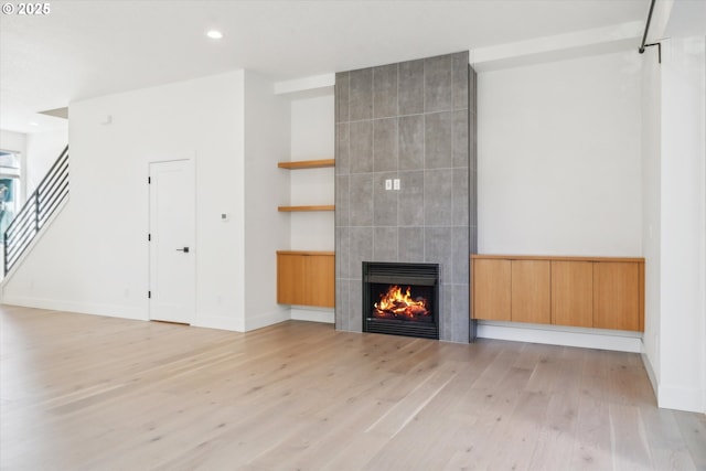 2585 SE 13th Ave, Portland, OR 97202 - unfurnished living room with light wood-style flooring, baseboards, recessed lighting, stairs, and a fireplace