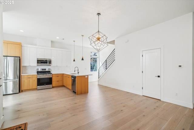 2585 SE 13th Ave, Portland, OR 97202 - kitchen with a sink, decorative backsplash, a chandelier, pendant lighting, and appliances with stainless steel finishes