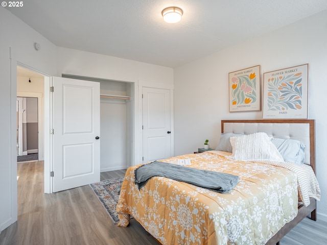 bedroom featuring a closet, baseboards, and wood finished floors