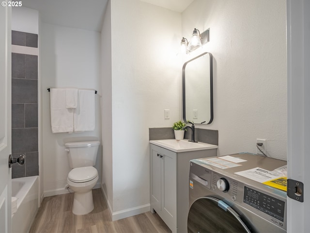 full bath with vanity, toilet, washer / clothes dryer, baseboards, and wood finished floors