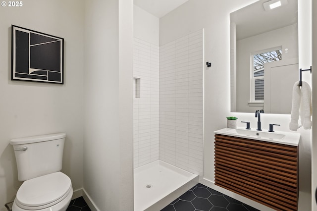 bathroom with tile patterned floors, vanity, toilet, and a tile shower