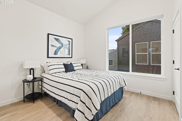 bedroom featuring light hardwood / wood-style floors and vaulted ceiling