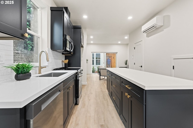 kitchen featuring backsplash, stainless steel appliances, sink, an AC wall unit, and a center island