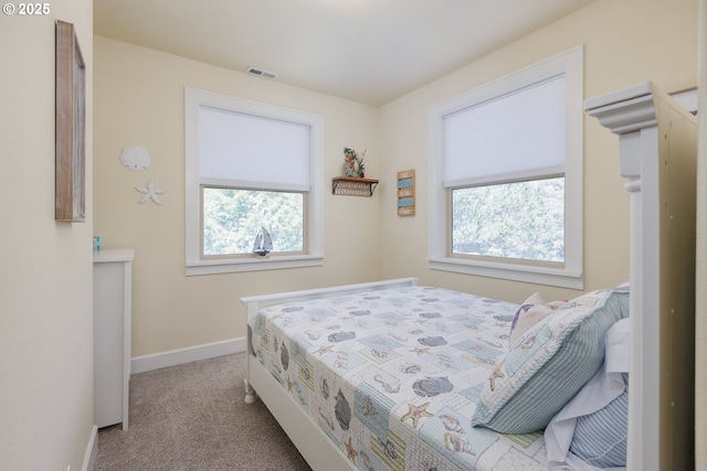 carpeted bedroom with visible vents and baseboards