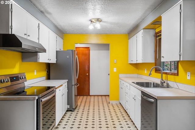 kitchen featuring stainless steel appliances, under cabinet range hood, a sink, light flooring, and white cabinetry