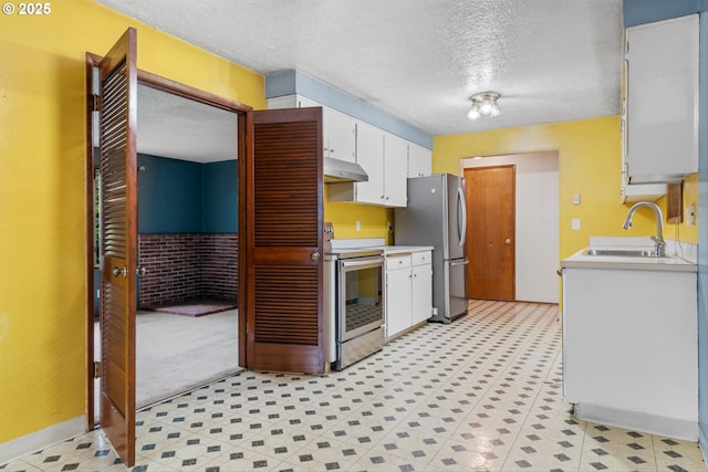 kitchen featuring stainless steel appliances, under cabinet range hood, a sink, light countertops, and a textured ceiling