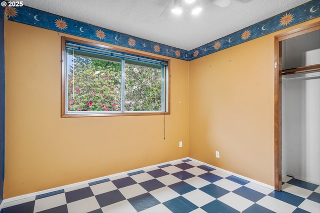 unfurnished bedroom with tile patterned floors, a textured ceiling, and a closet