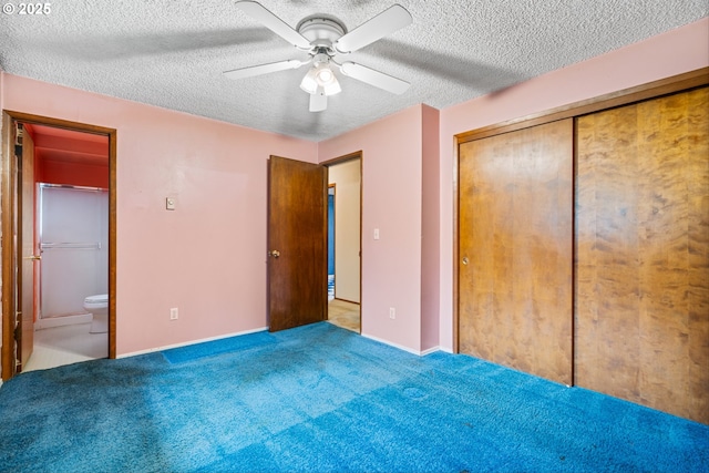unfurnished bedroom with a textured ceiling, ceiling fan, ensuite bath, baseboards, and a closet