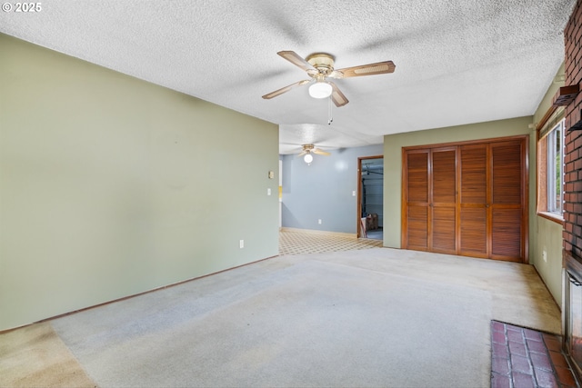 unfurnished bedroom with carpet flooring, a closet, ceiling fan, a textured ceiling, and baseboards