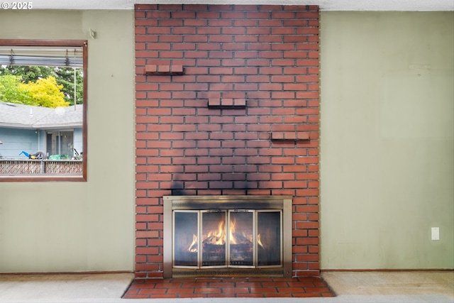detailed view of a brick fireplace, baseboards, and a textured ceiling