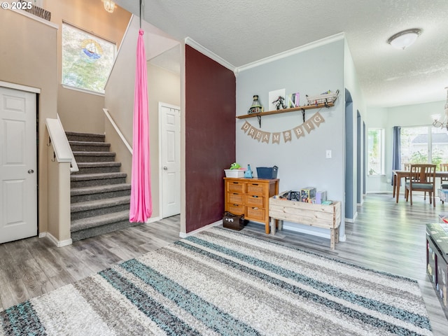 35530 Edies Way, Saint Helens, OR 97051 - stairs featuring wood finished floors, a chandelier, plenty of natural light, a textured ceiling, and ornamental molding