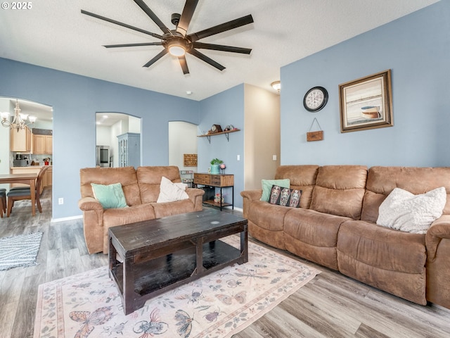 35530 Edies Way, Saint Helens, OR 97051 - living room with arched walkways, ceiling fan, light wood-style floors, and a chandelier
