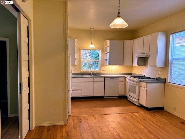 74 NE Sacramento St, Portland, OR 97213 - kitchen with white gas range oven, dishwasher, light wood finished floors, white cabinetry, and pendant lighting