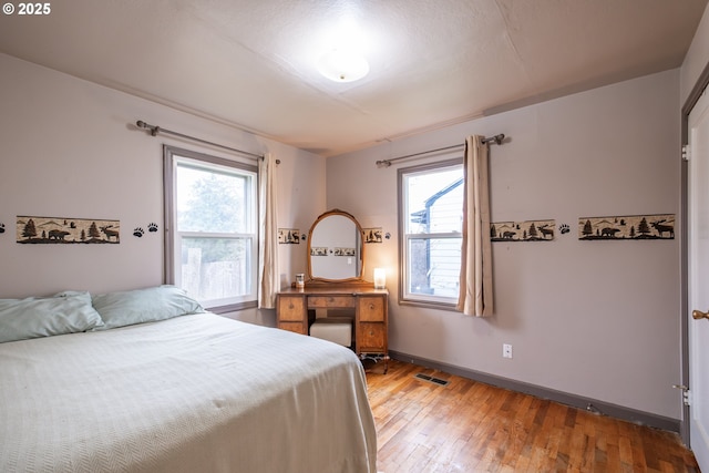 bedroom featuring visible vents, baseboards, and light wood-style floors