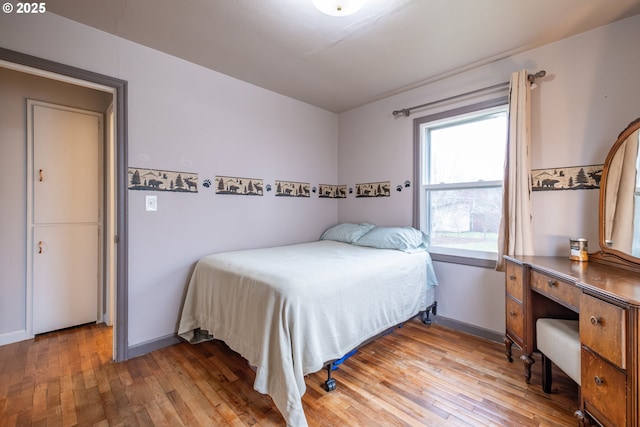 bedroom with light wood-type flooring and baseboards