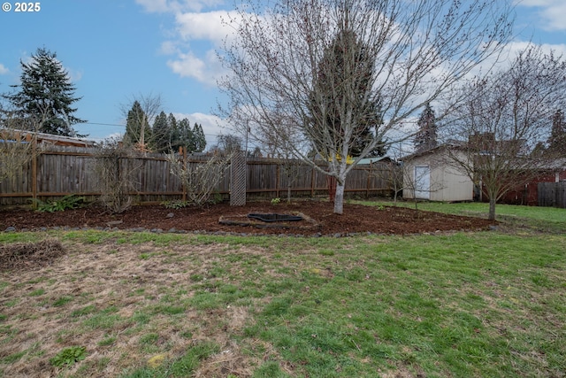 view of yard with a fenced backyard, an outdoor structure, and a shed