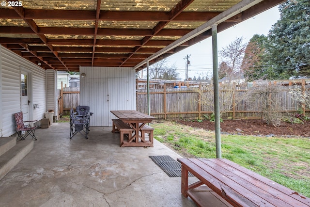 view of patio with a storage unit, an outdoor structure, and a fenced backyard