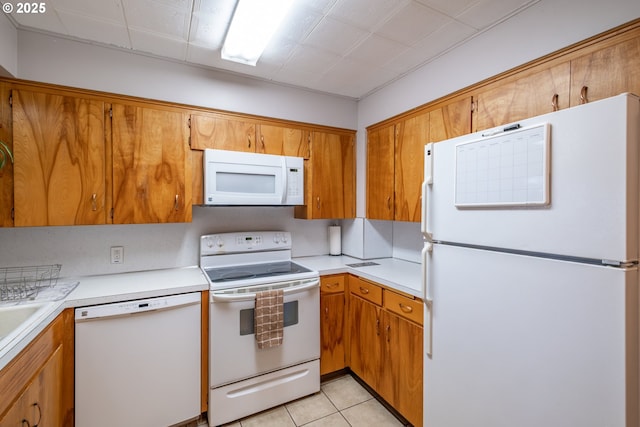 kitchen with brown cabinets, white appliances, and light countertops