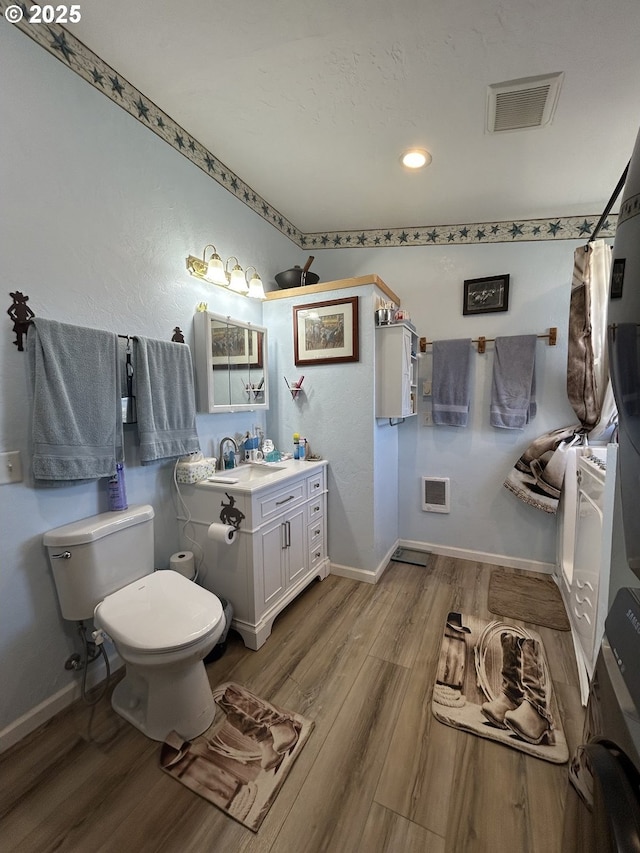 37102 Woods Ln, Richland, OR 97870 - full bath with visible vents, toilet, wood finished floors, and baseboards