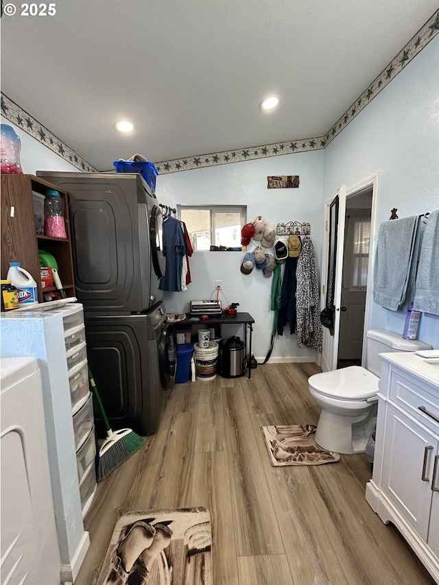 37102 Woods Ln, Richland, OR 97870 - bathroom featuring vanity, recessed lighting, toilet, wood finished floors, and stacked washer and clothes dryer