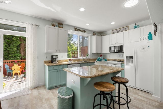 19774 SW Ashcroft Ln, Beaverton, OR 97003 - kitchen with white appliances, a sink, light wood-style flooring, a center island, and recessed lighting