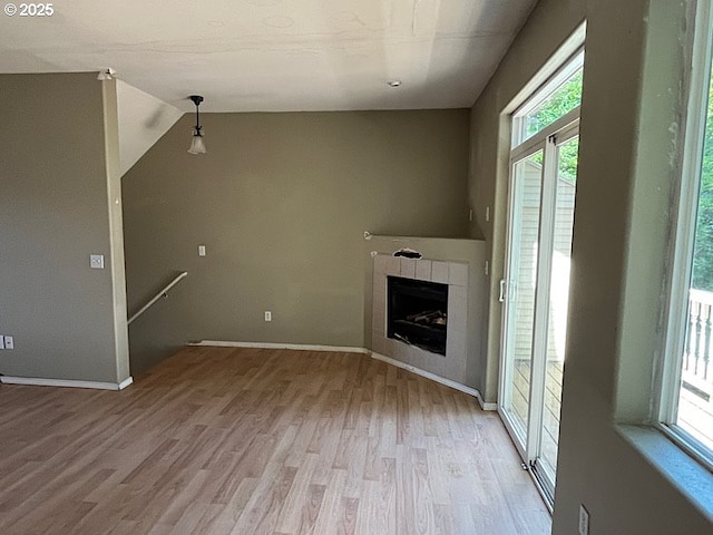 19903 SW Poplarwood Pl, Tualatin, OR 97062 - unfurnished living room with plenty of natural light, wood finished floors, and a tiled fireplace