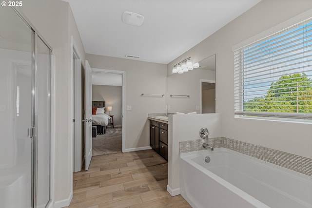 2908 S White Salmon Dr, Ridgefield, WA 98642 - ensuite bathroom featuring vanity, a stall shower, wood finished floors, and healthy amount of natural light
