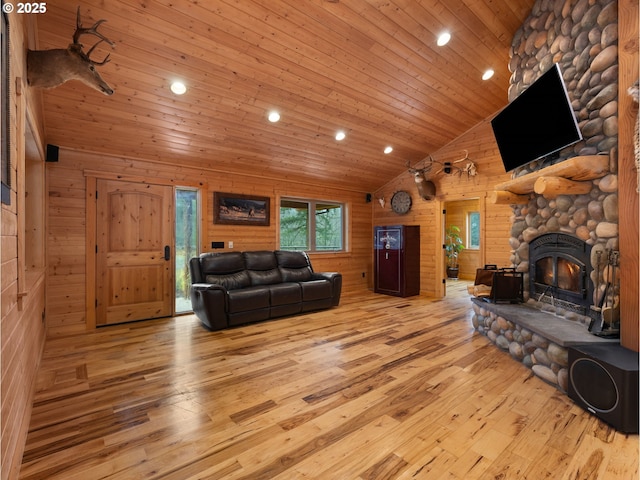 living room featuring wooden walls, hardwood / wood-style flooring, wood ceiling, a fireplace, and high vaulted ceiling