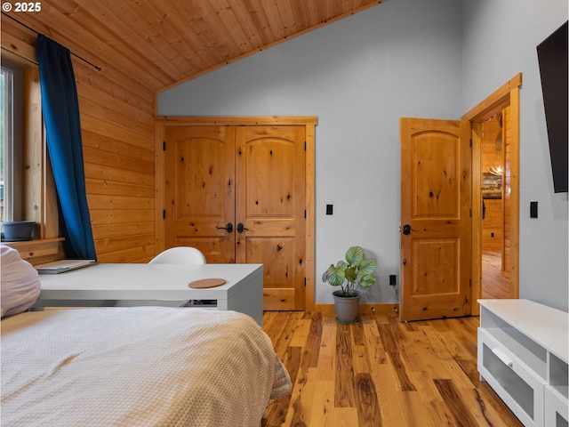 bedroom with light wood finished floors, wood ceiling, and vaulted ceiling