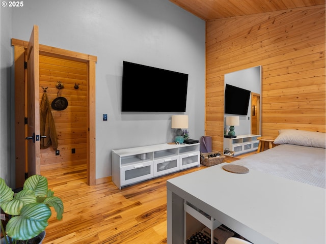 bedroom featuring wood ceiling, wood walls, and light wood-style flooring