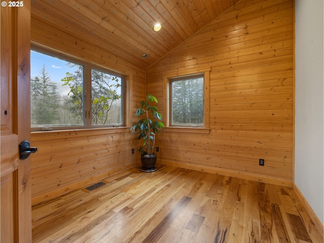 empty room with visible vents, lofted ceiling, wooden ceiling, a sauna, and wood finished floors