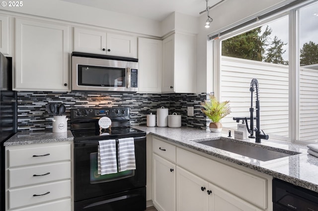 kitchen featuring sink, dishwashing machine, white cabinets, and black / electric stove