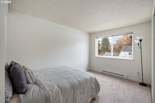 bedroom featuring baseboard heating, a textured ceiling, and light carpet