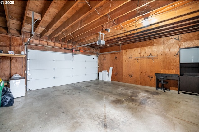 garage featuring a garage door opener and wood walls