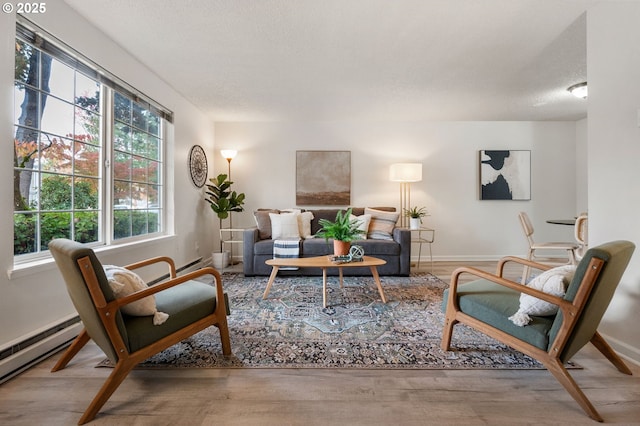 sitting room with a textured ceiling, hardwood / wood-style flooring, and a baseboard radiator