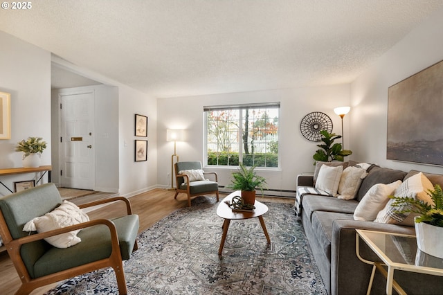 living room with wood-type flooring, a baseboard heating unit, and a textured ceiling