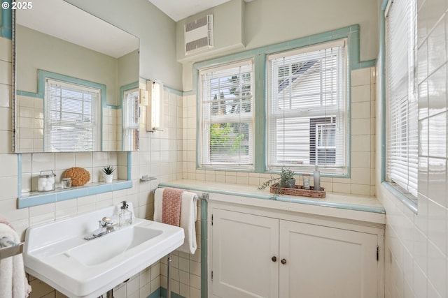 bathroom featuring tile walls, a wealth of natural light, a sink, and visible vents