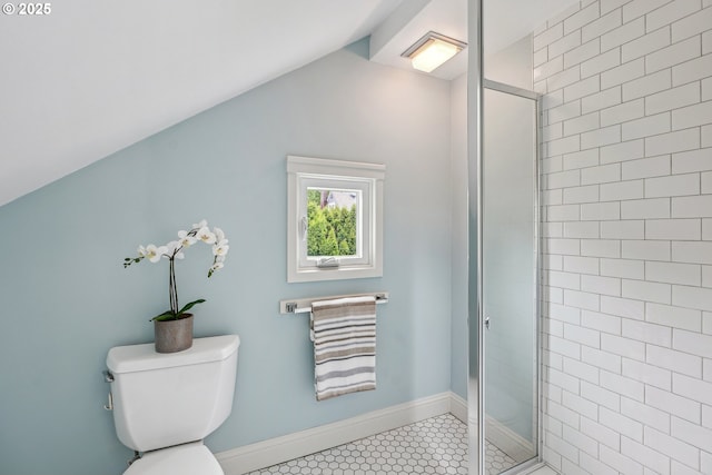 bathroom with toilet, tile patterned floors, vaulted ceiling, and a shower stall
