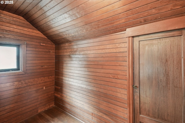 interior space with wood walls, wooden ceiling, and lofted ceiling