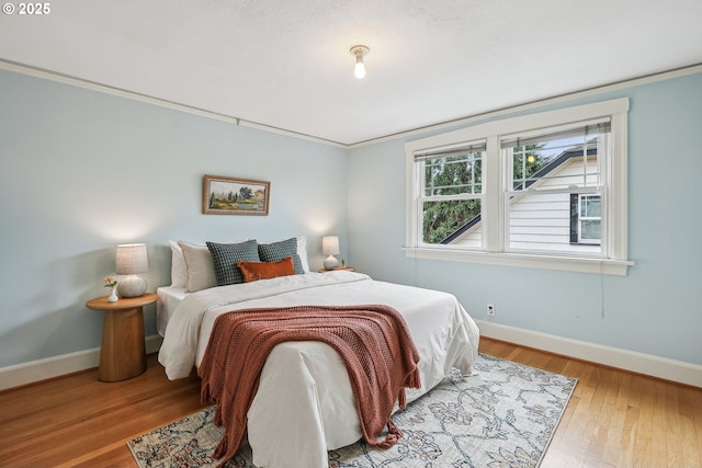 bedroom with baseboards and wood finished floors