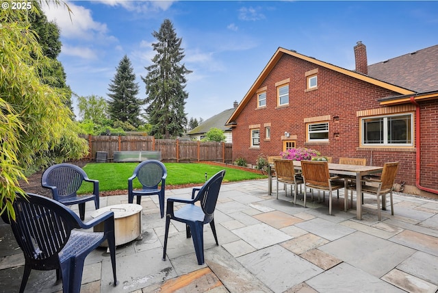 view of patio / terrace with outdoor dining area, a fire pit, and a fenced backyard