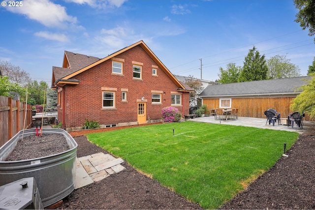 back of property with a yard, brick siding, fence, and a patio area
