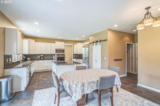 26250 S Milk Creek Cir, Mulino, OR 97042 - dining area featuring a barn door, baseboards, and recessed lighting