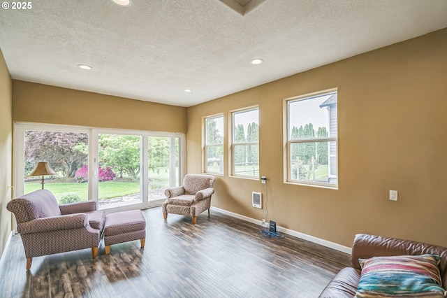 living area with a textured ceiling, baseboards, recessed lighting, and wood finished floors