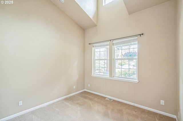 unfurnished room featuring light colored carpet, baseboards, and lofted ceiling