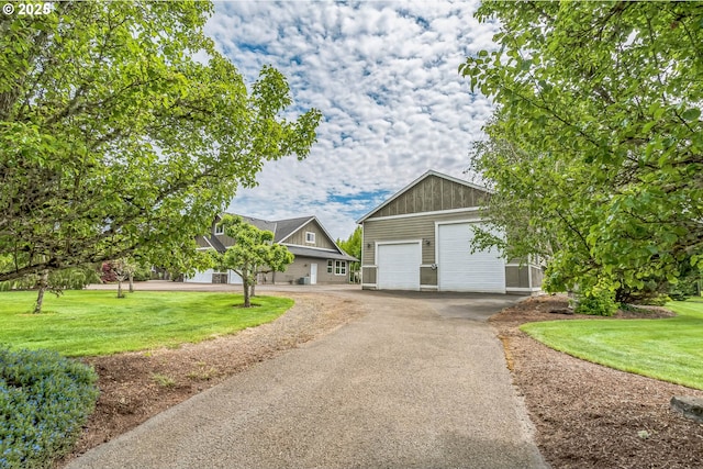 view of front of property featuring a front yard, a garage, asphalt driveway, and board and batten siding