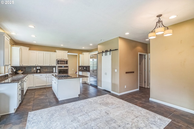 kitchen featuring stainless steel appliances, a sink, a center island, baseboards, and recessed lighting