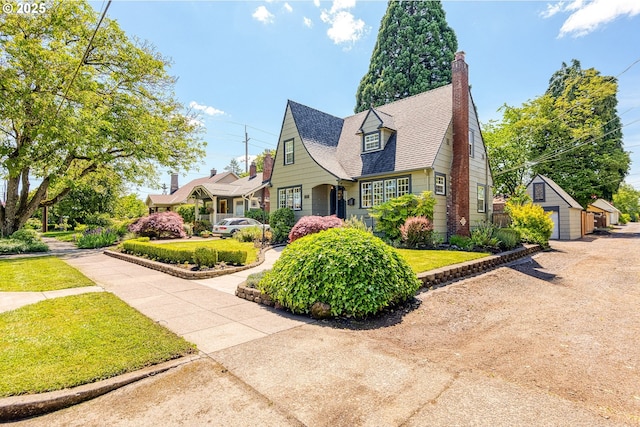226 N Highland St, Portland, OR 97217 - view of front of home with an outdoor structure, a front lawn, a chimney, and a shingled roof