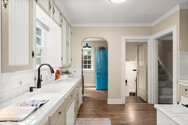 226 N Highland St, Portland, OR 97217 - kitchen featuring tile countertops, dark wood-style flooring, plenty of natural light, a sink, and crown molding